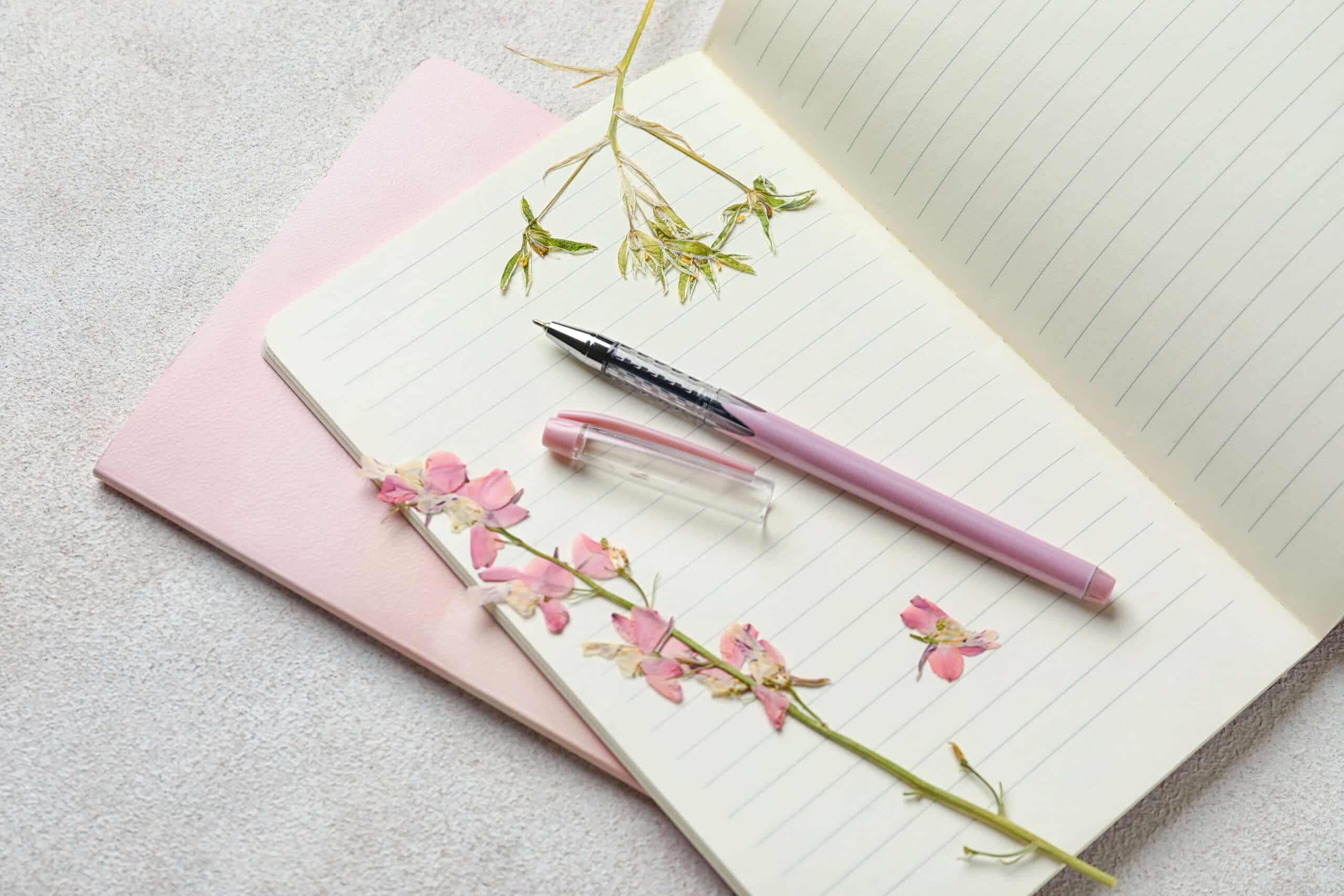 Notebooks, pen and dry pink flowers