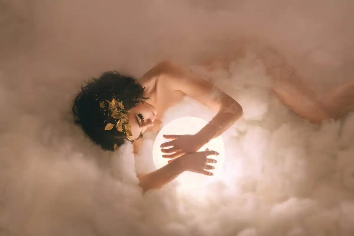 A naked goddess, lies in the clouds and hugs the glowing moon