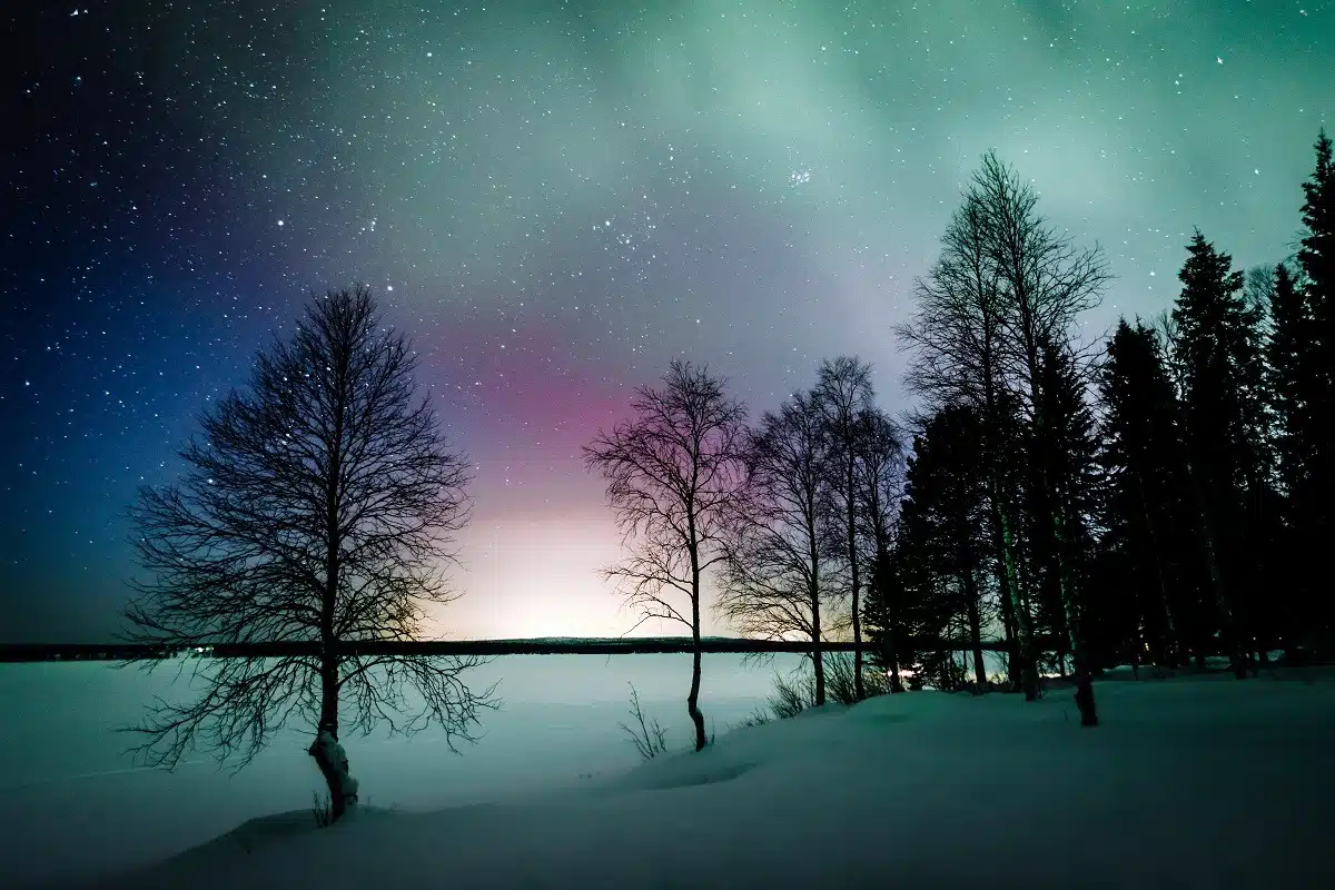 Northern lights Aurora Borealis activity over the lake in winter