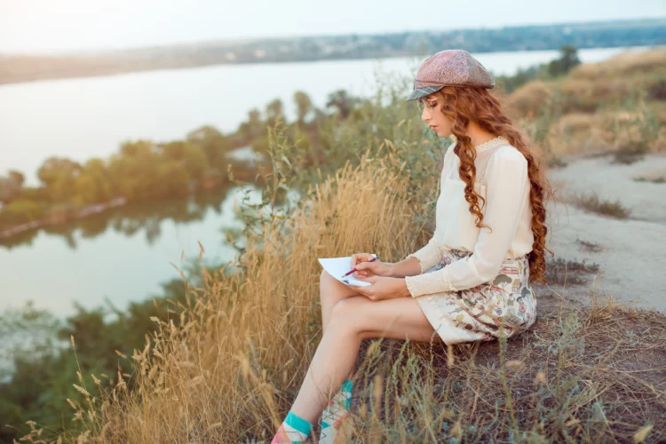 pretty writer by the river in nature.