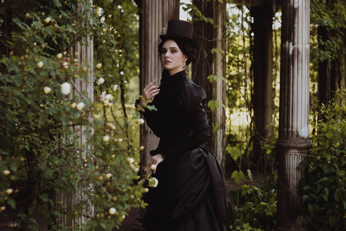 a young vintage lady in black dress in the garden