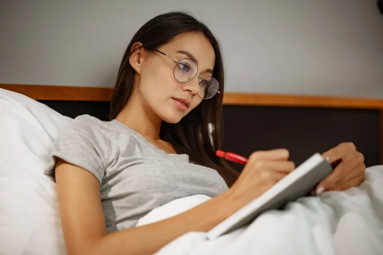 woman writing in bed
