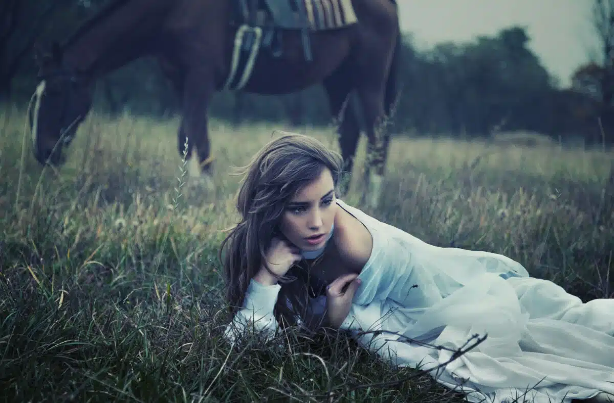 young beauty on the grass with her horse