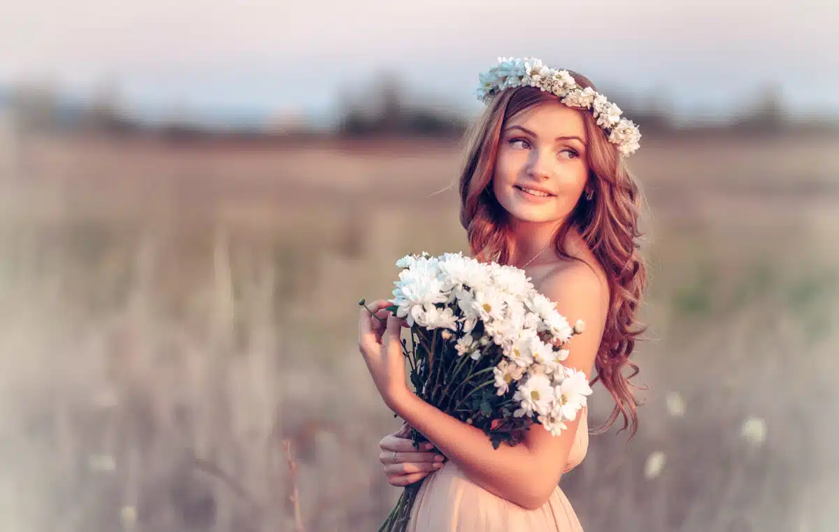 a beautiful girl in a chamomile wreath