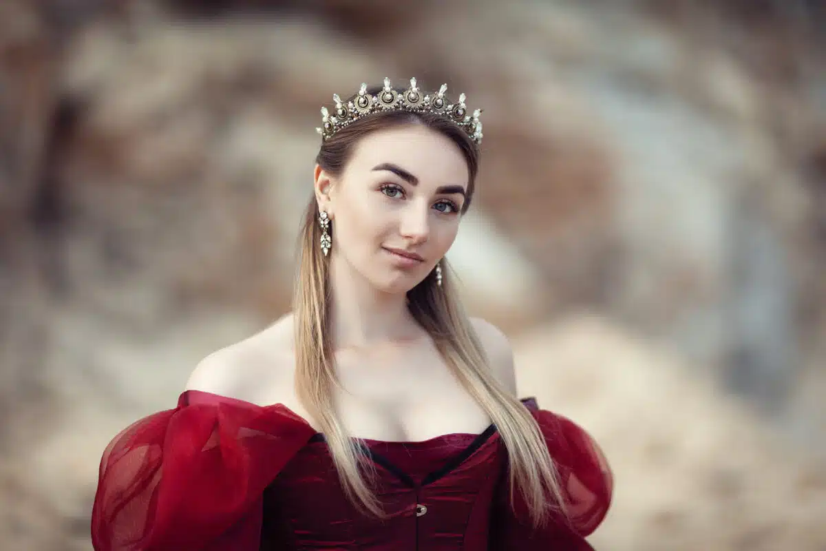 a beautiful girl in a red dress and a crown