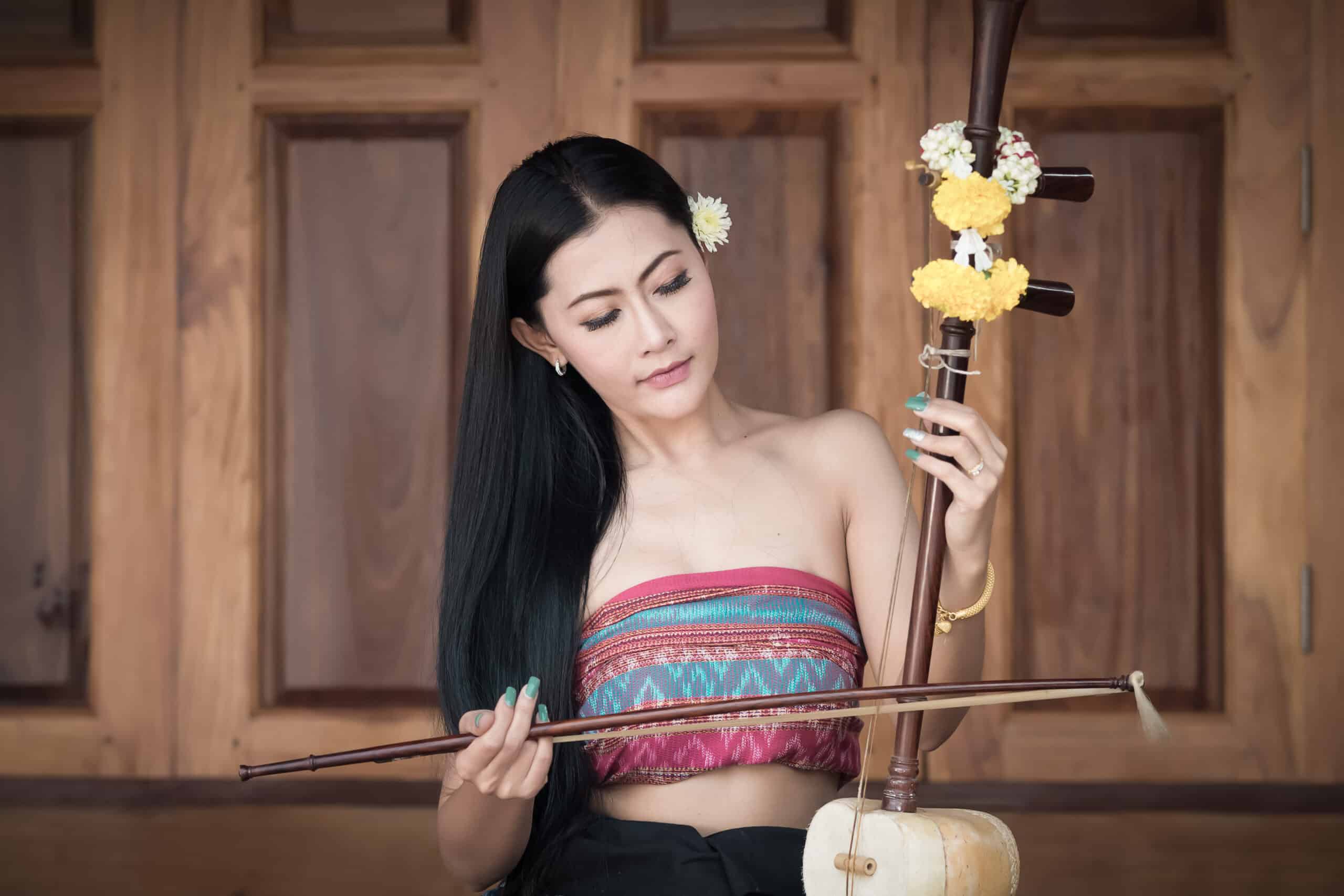 Beautiful Asian girl in traditional costume with a fiddle.