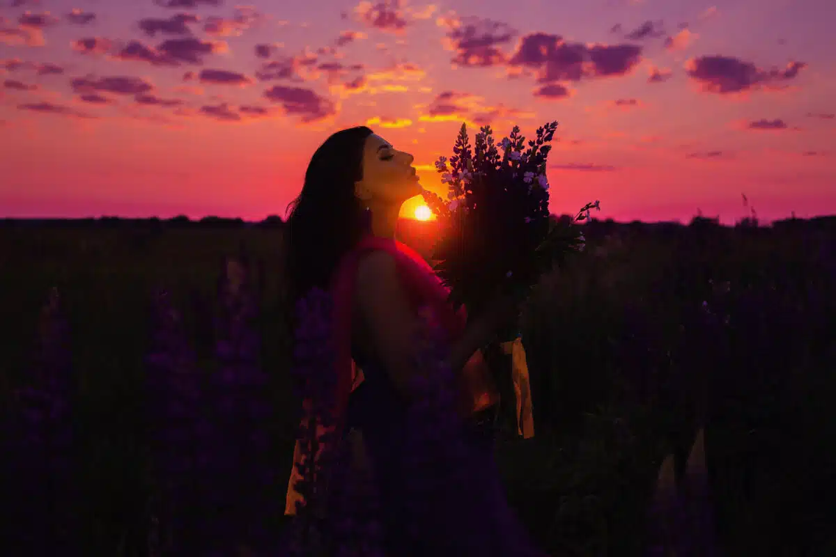 A brunette girl in dress with sunset in the background