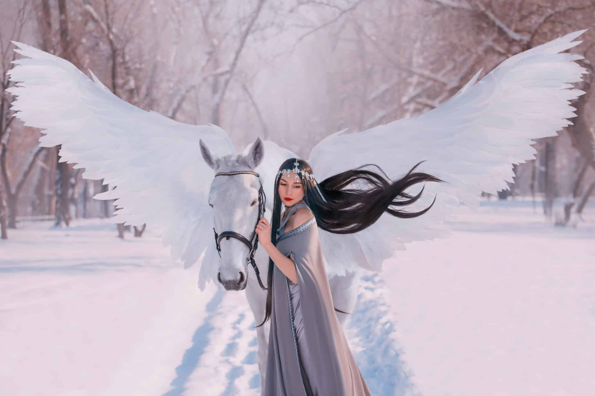 Young beautiful elf princess woman stroking mythical animal unicorn horse. 