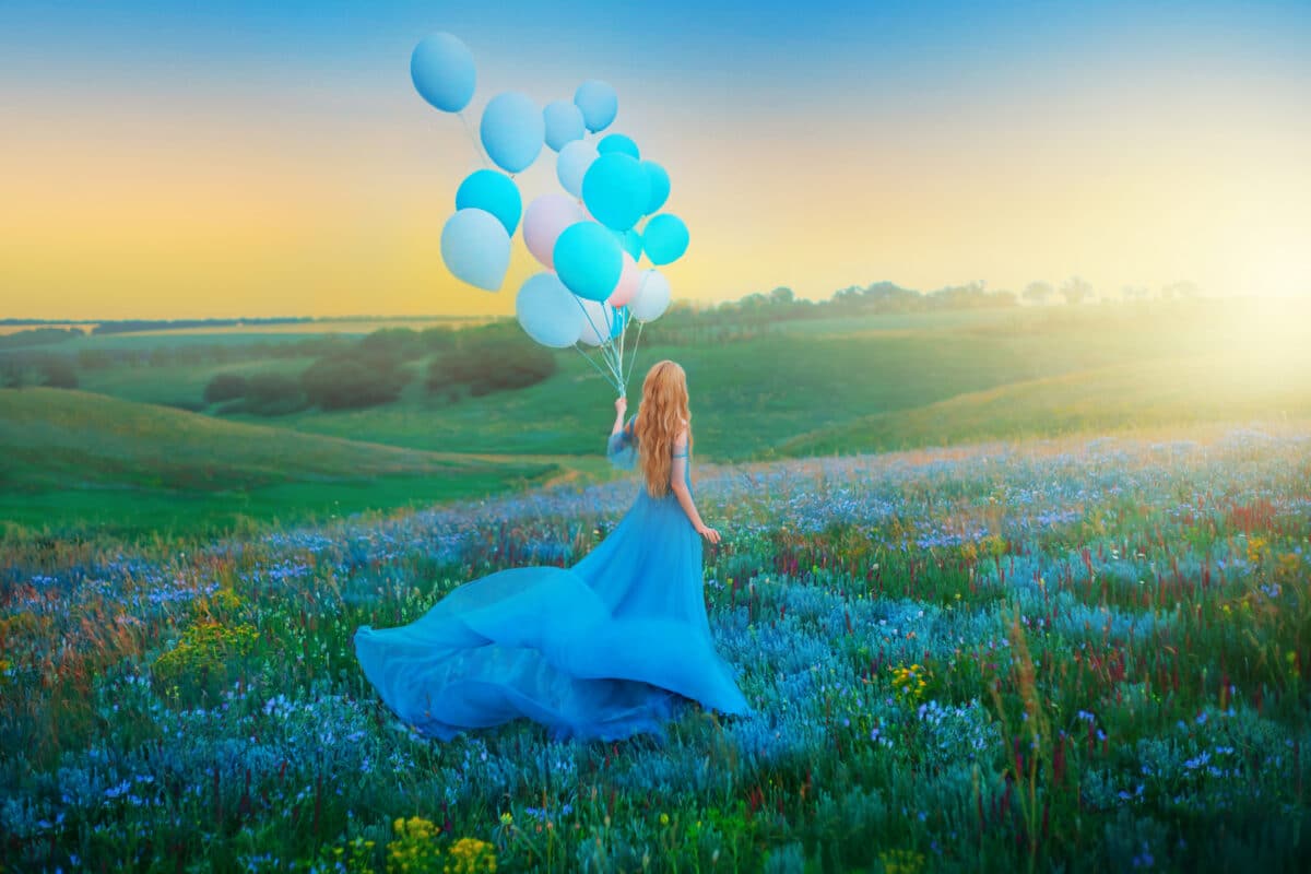 Artwork. Silhouette in motion happy woman. Fantasy girl princess holding in hand ball air balloon. long blue dress fluttering fly in wind. Sunset sky fog, flowers green meadow. blond hair back view 
