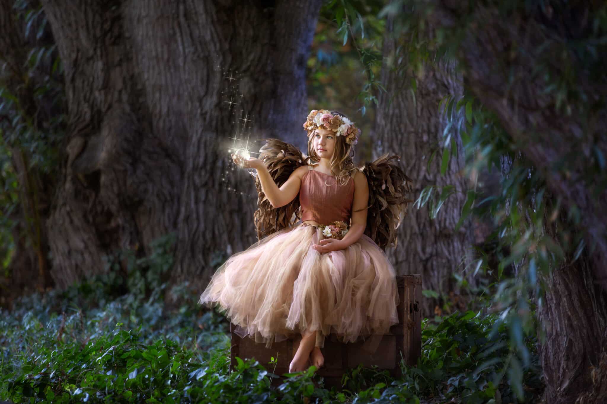 Young fairy holding a magical crystal ball in the woods