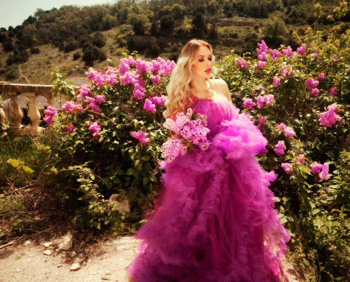 beautiful girl in a purple dress in a lilac garden