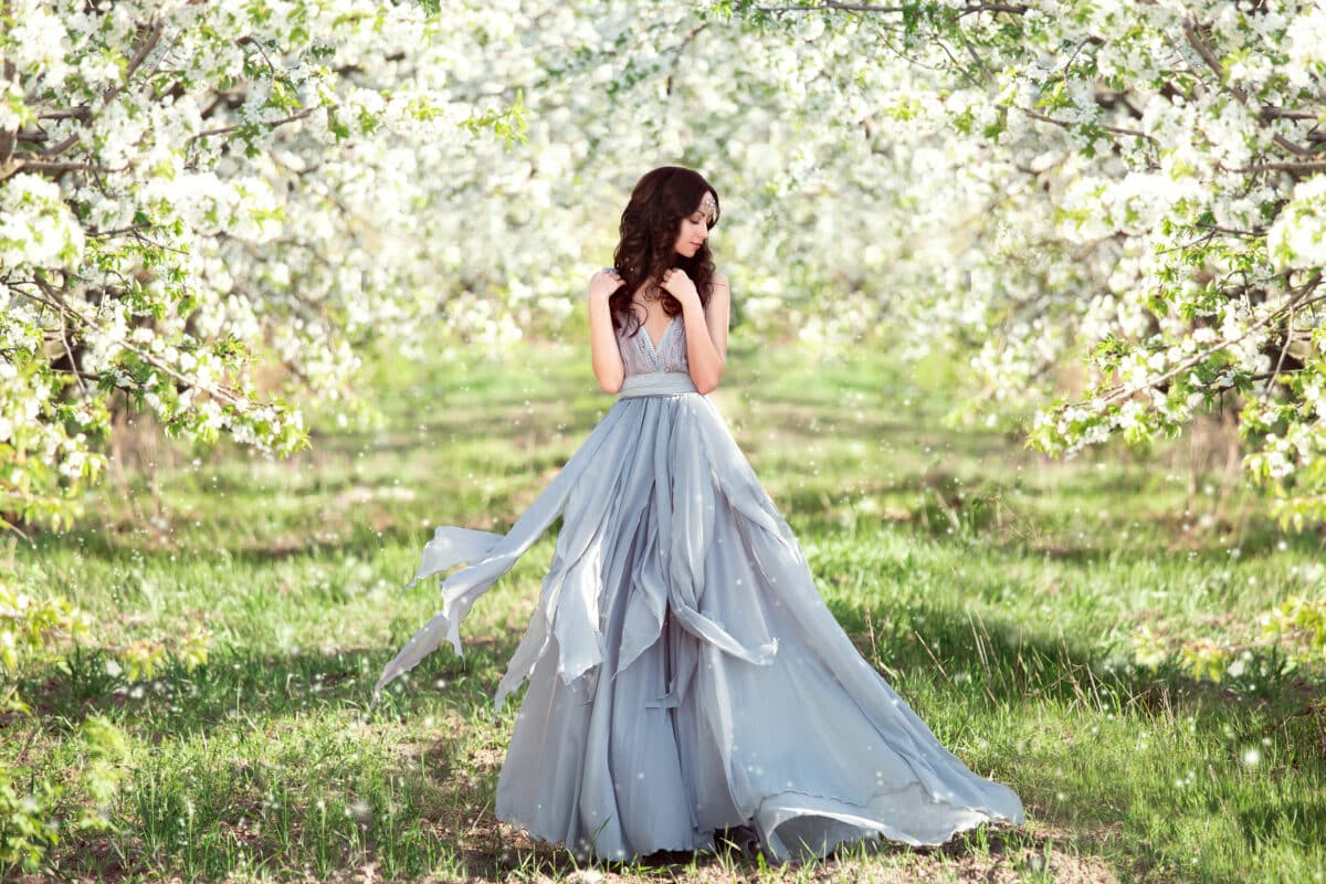 beautiful spring walk in the garden among the blooming trees in April. a lady in a long dress pastel , creative computer colors, fashionable toning