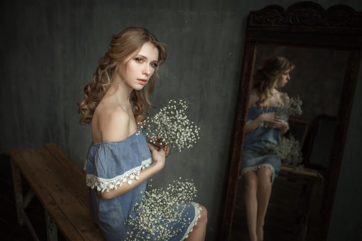 sad beautiful blonde with flowers indoors