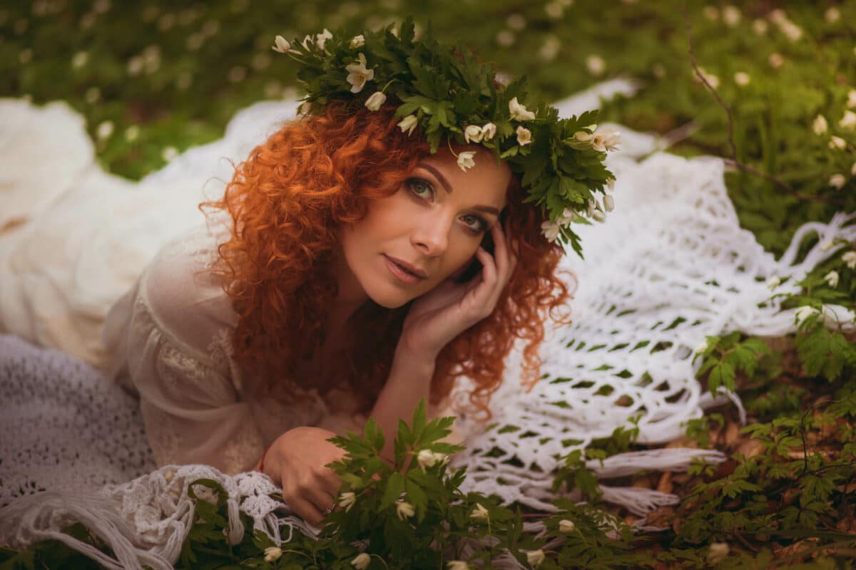 incredibly beautiful red-haired woman in wreath lying
