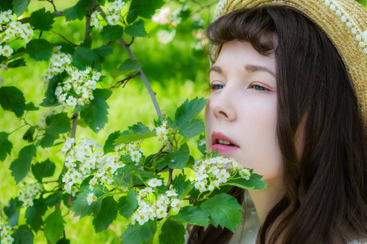 Girl in a garden in hawthorn flowers