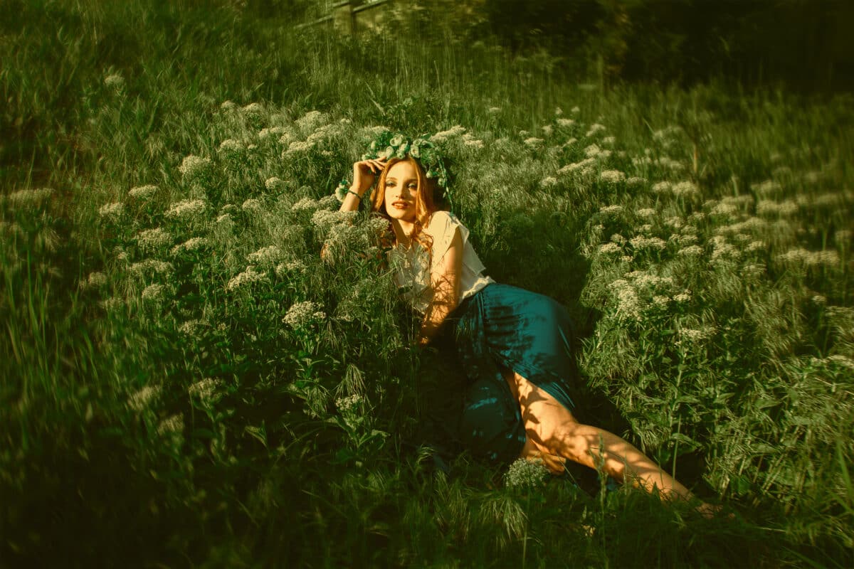 woman lying in the grass with wreath on her head