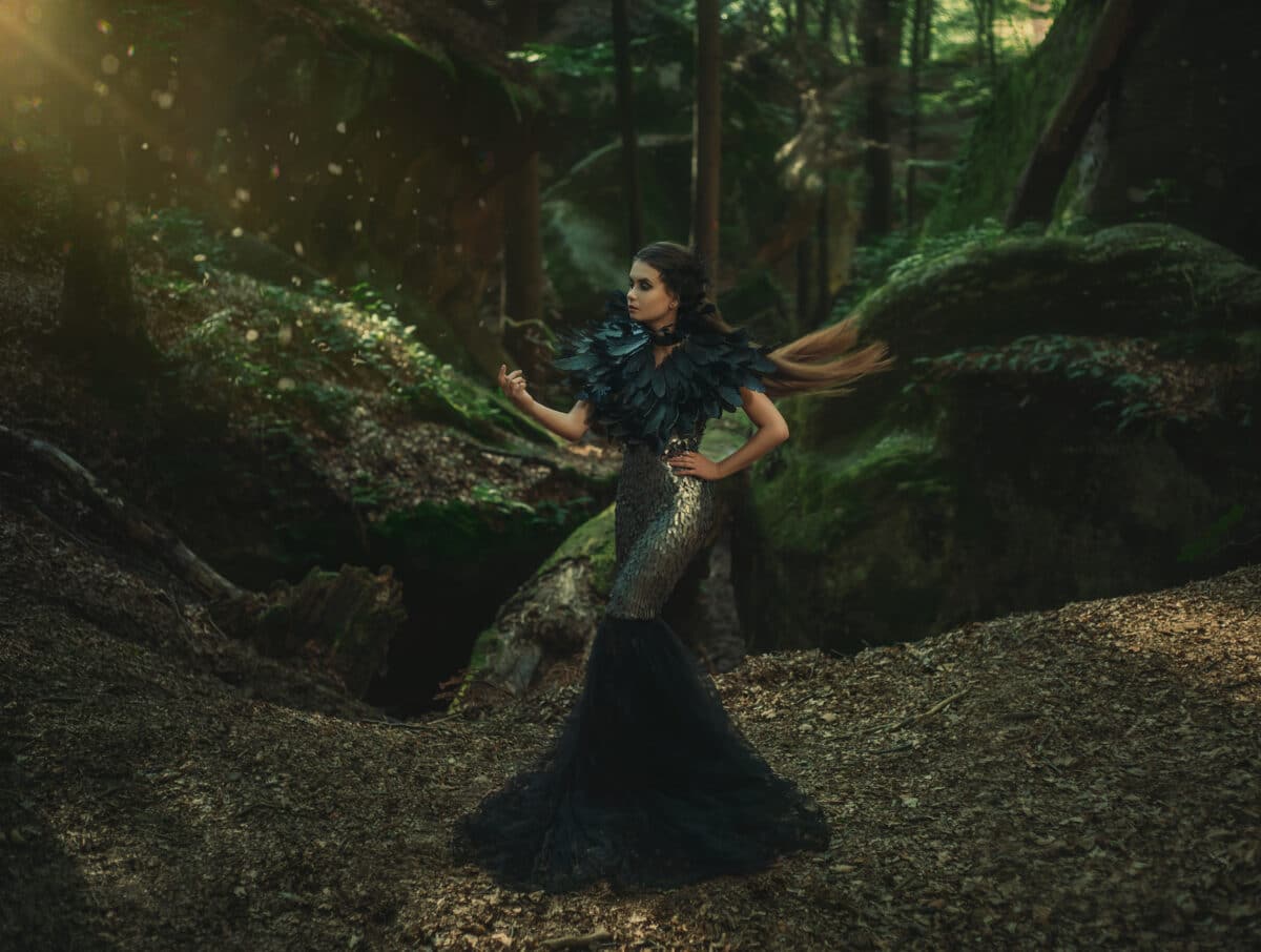 Girl - black raven wanders in the mountains. Gothic photo session theme of Halloween. Unusual, creative outfit