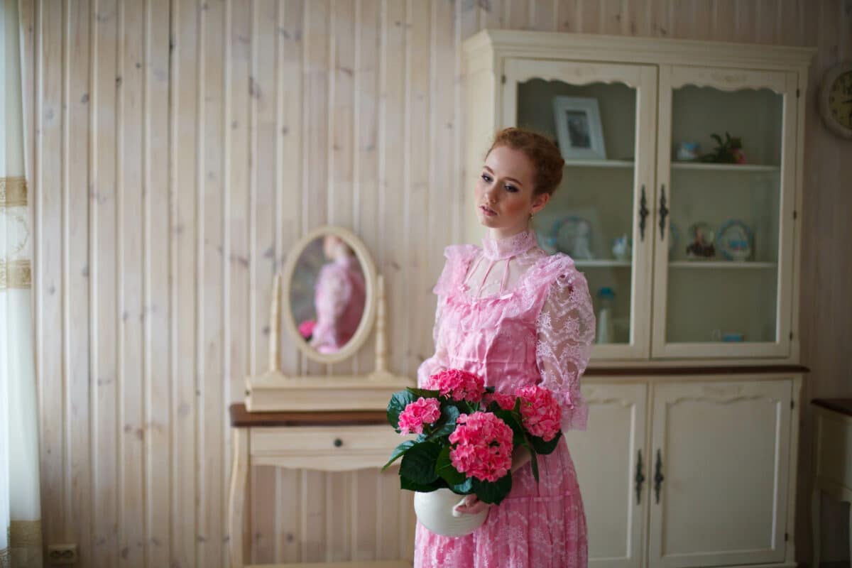 a beautiful red-haired girl in vintage pink dress