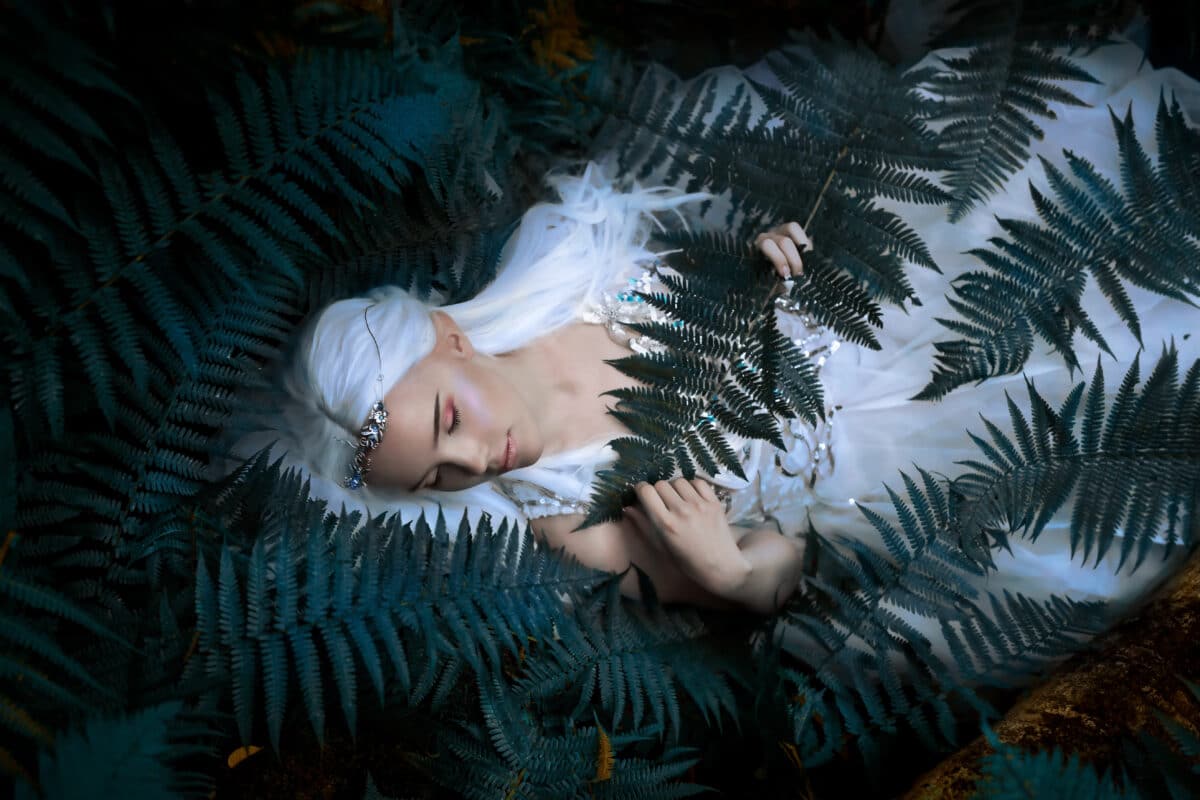 Portrait of a sleeping mysterious Elf princess in summer forest