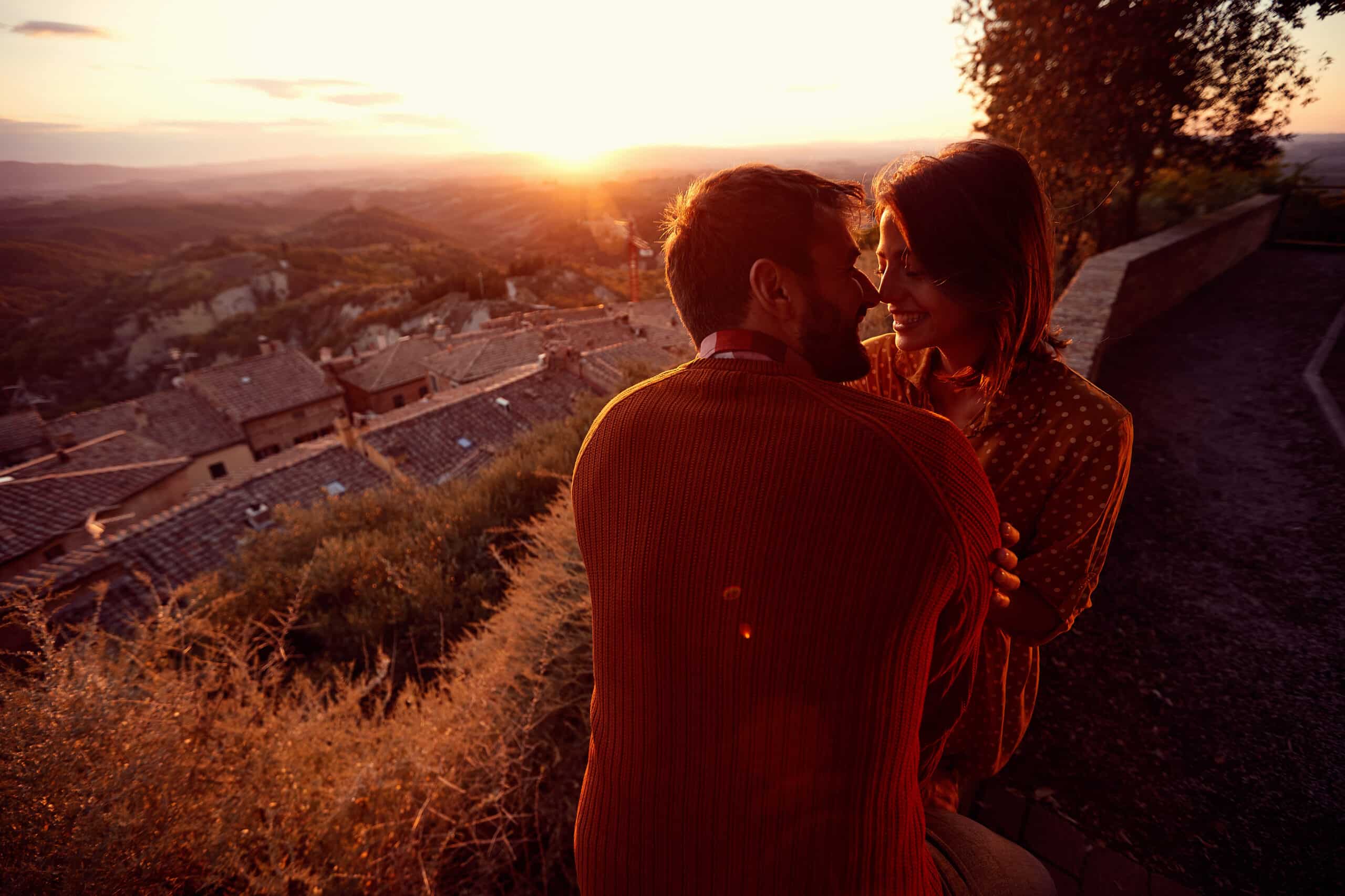 romantic man and woman kissing at sunset