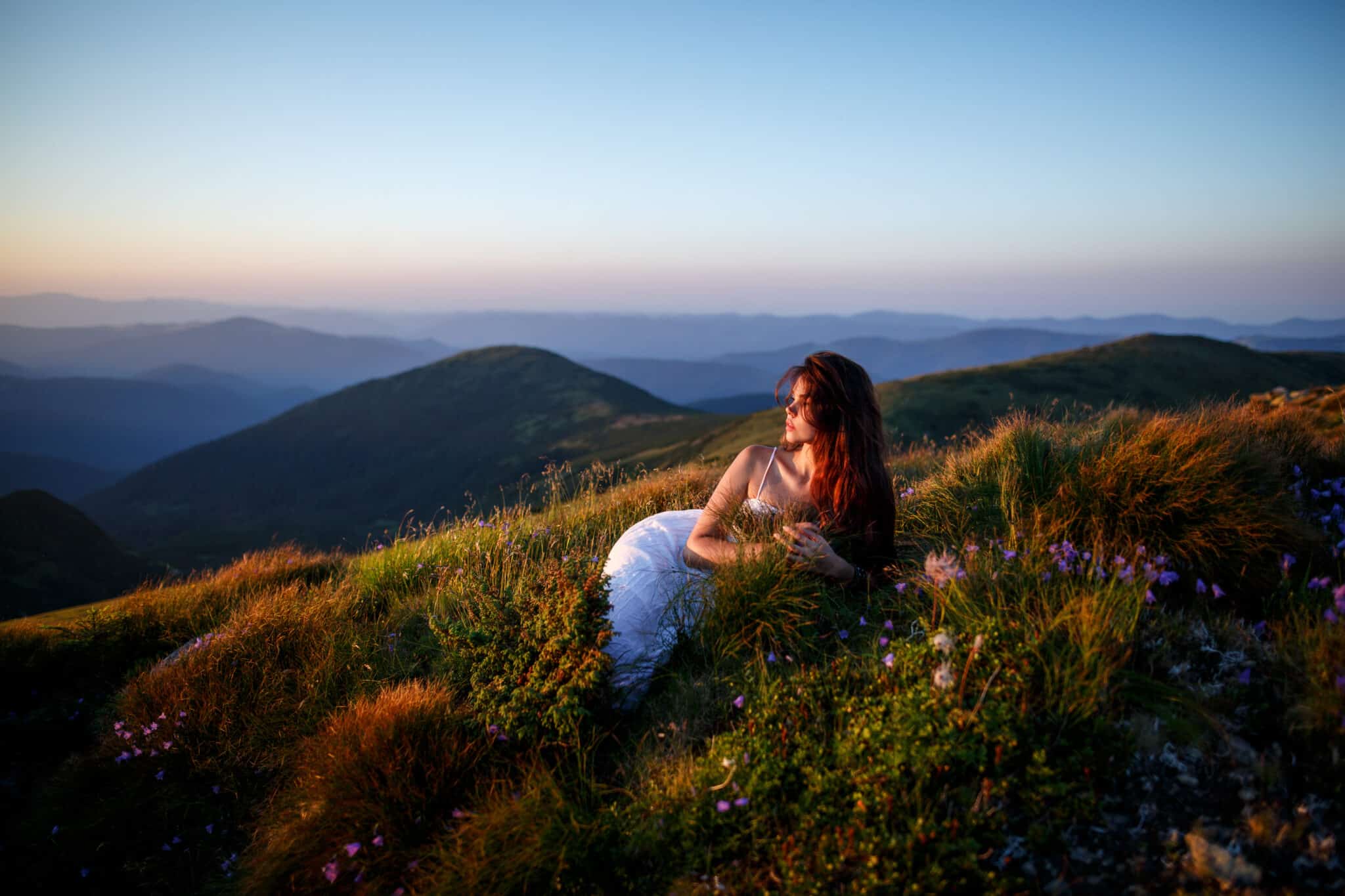 Young woman in long white dress in the mountains