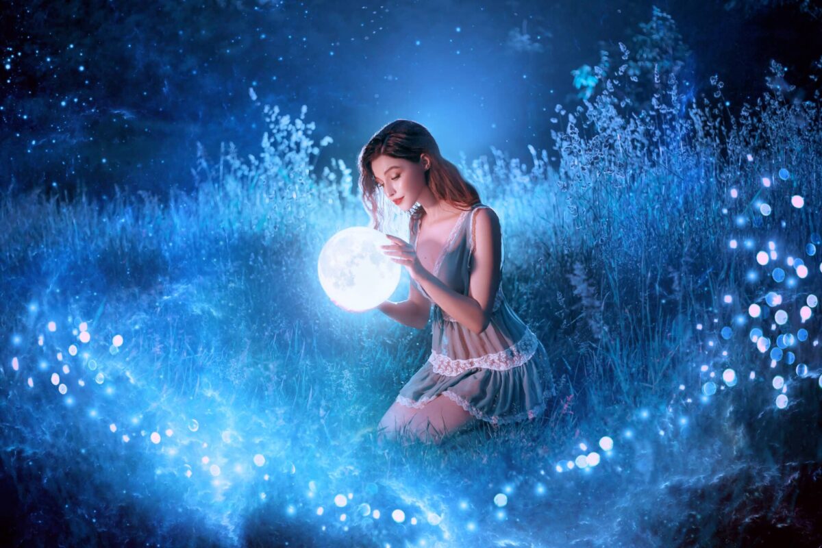 a pretty fairy holds in hands magical ball while sitting in the blue night forest
