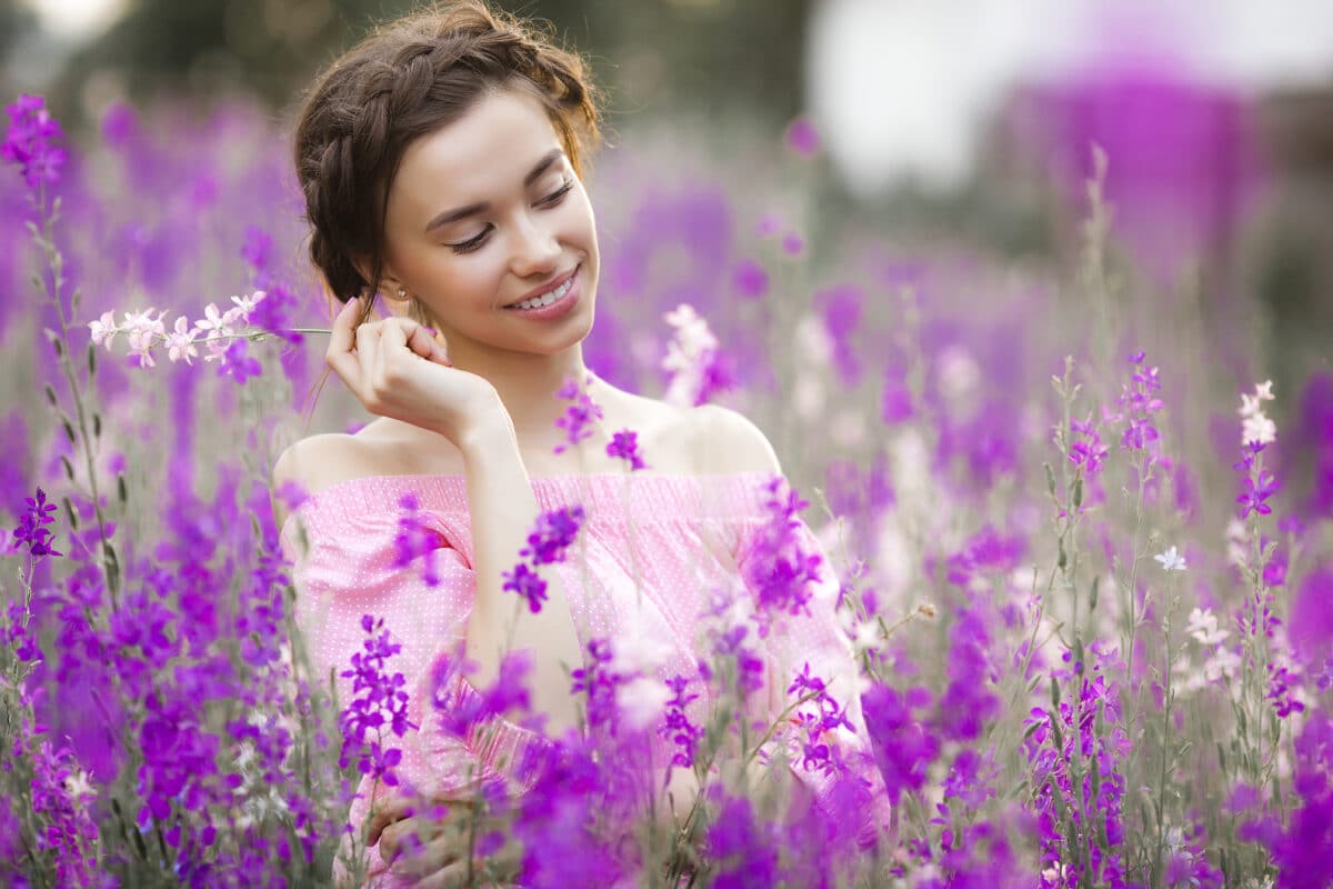 elegant woman on the meadow with pink wild flowers