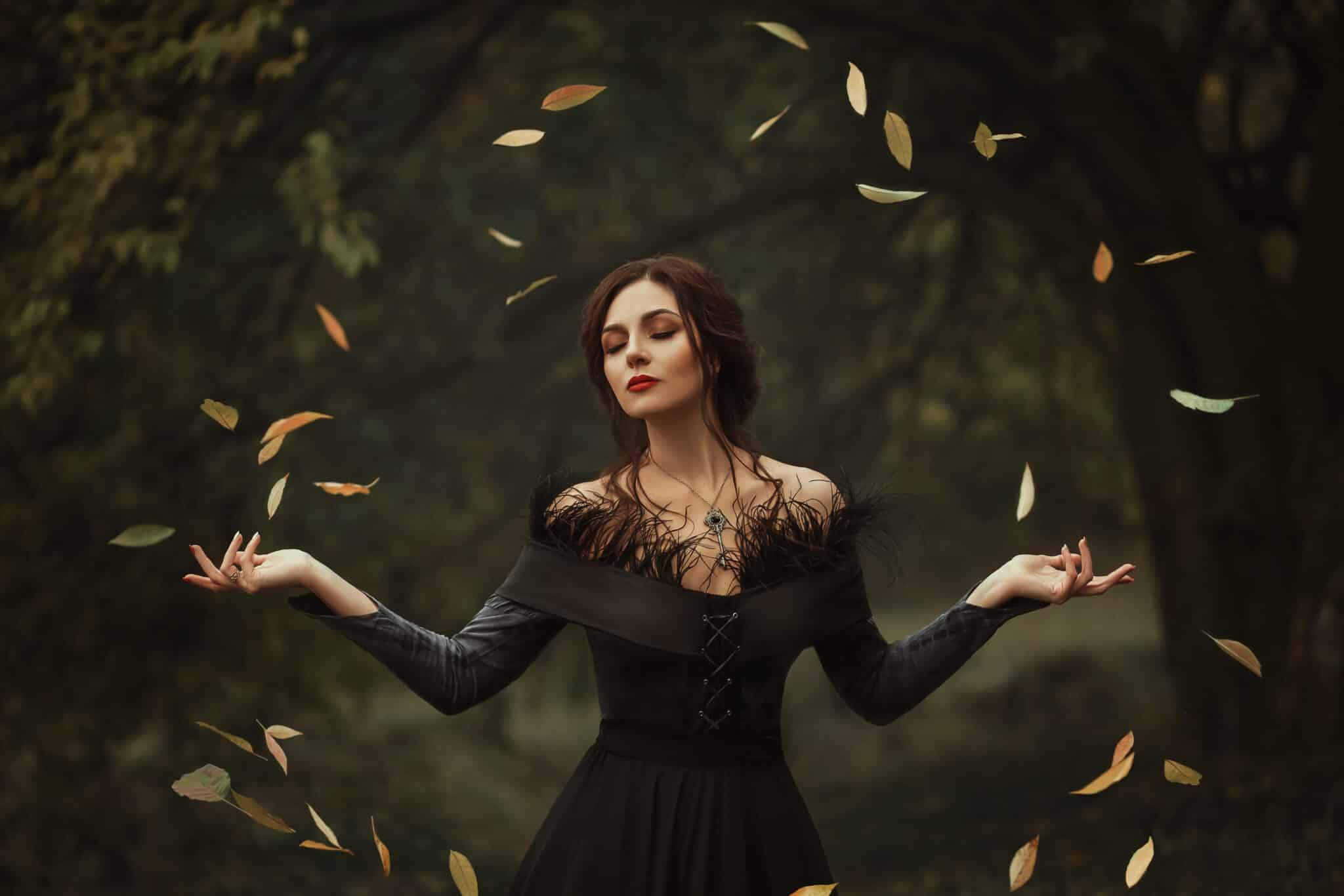 Incredible, amazing, seductive girl, in a black dress , magic rotates the leaves.