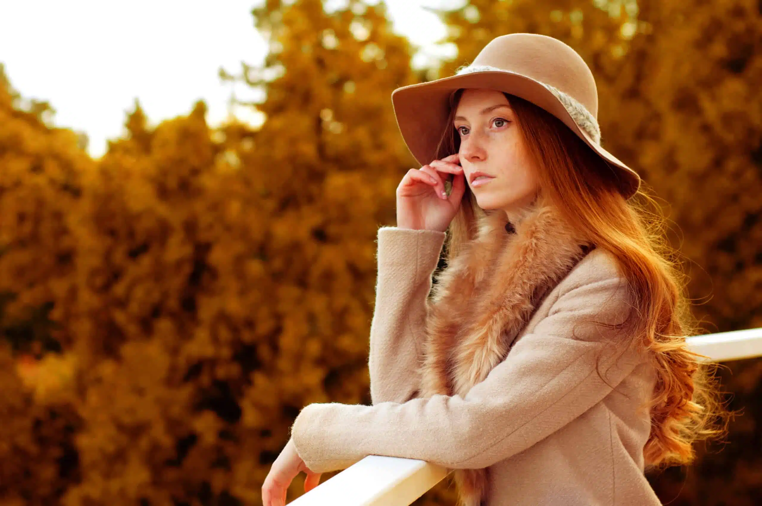 Woman with long red hair, fedora hat and fur coat