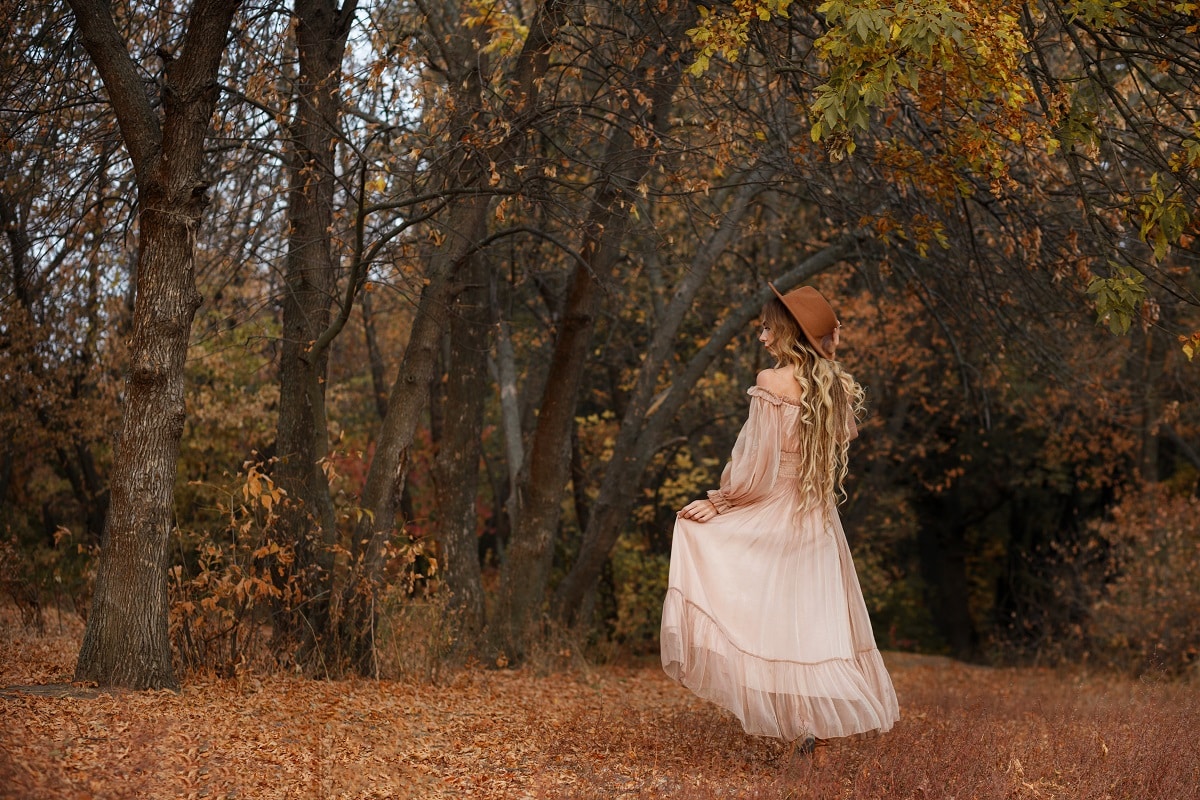 lady in a white in dress and hat in autumn fairy forest