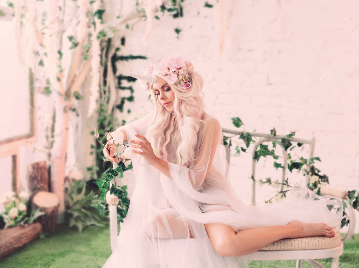 Wonderful creation, the girl is a unicorn in light, white, slightly transparent attire. The background is a bright room that is overgrown with plants, moss, ivy, trees and flowers.