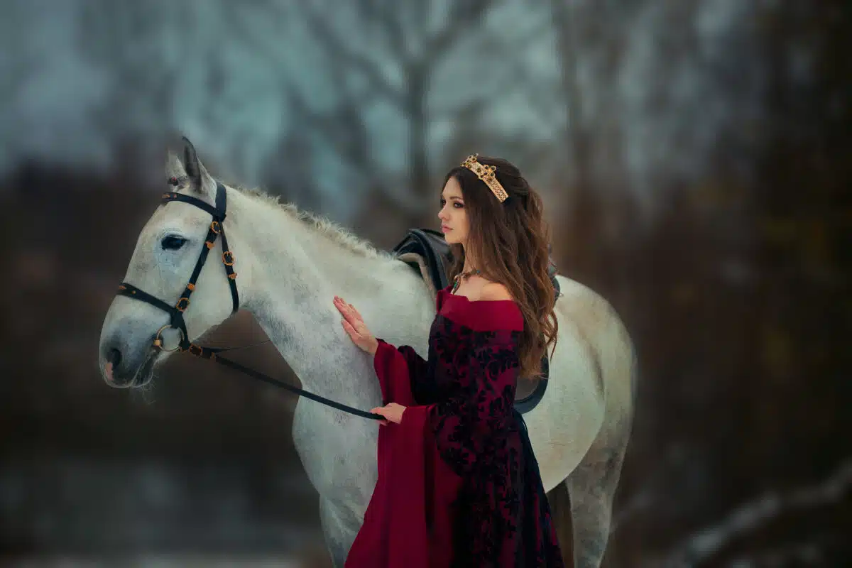 Medieval Queen on white horse at twilight winter forest