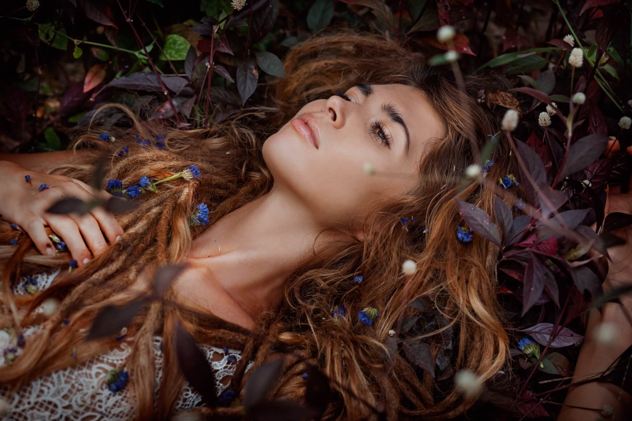 beautiful girl lying on the grass with flowers
