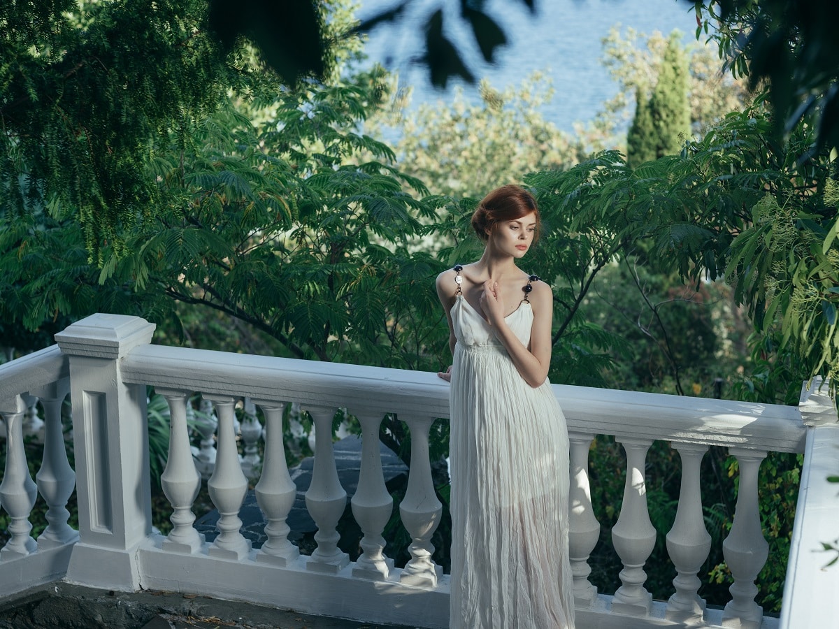 greek goddess in white dress on the marble balcony