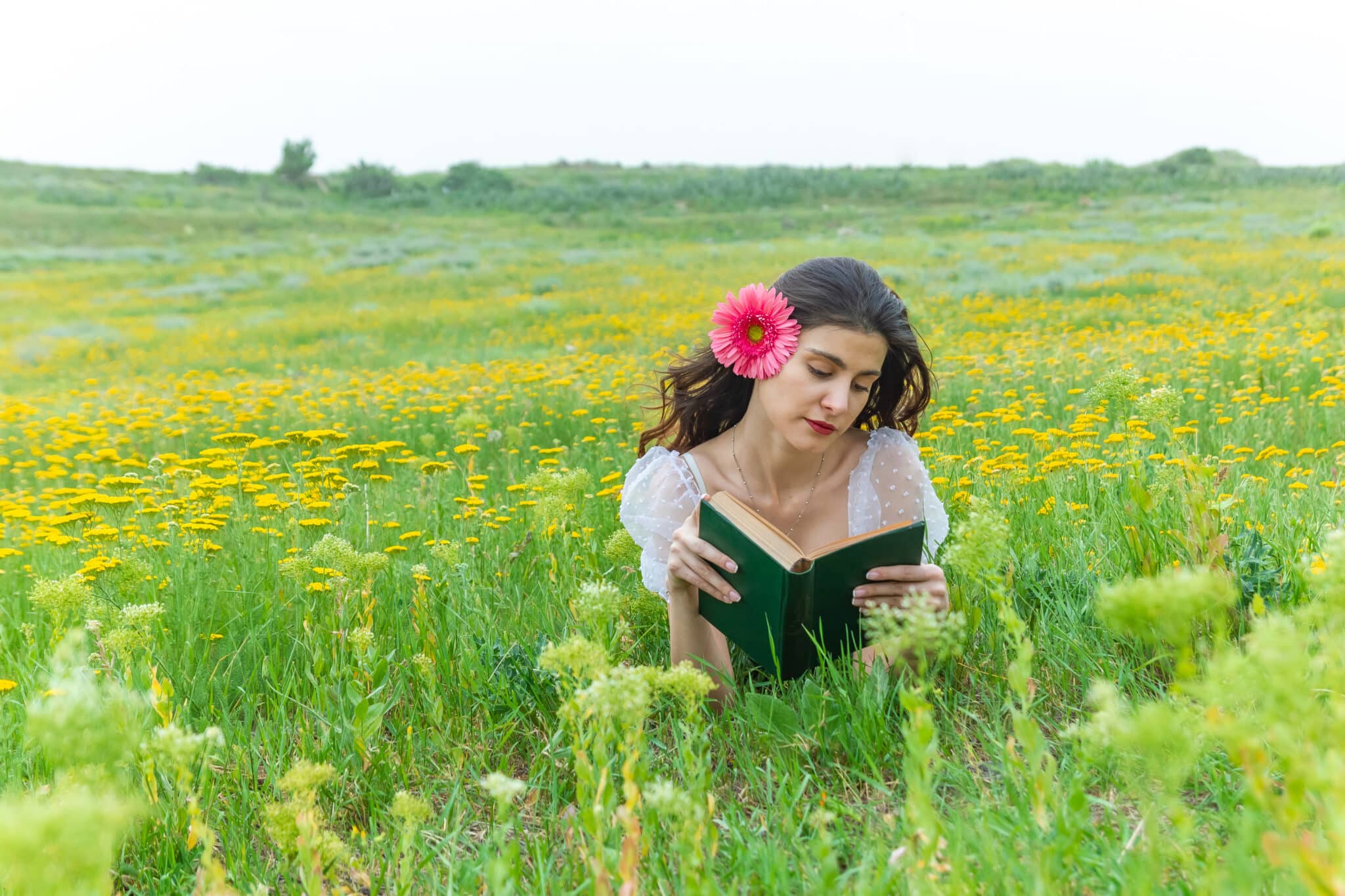 pretty young woman in the field reading the book, woman reading a book, girl in a field with flower