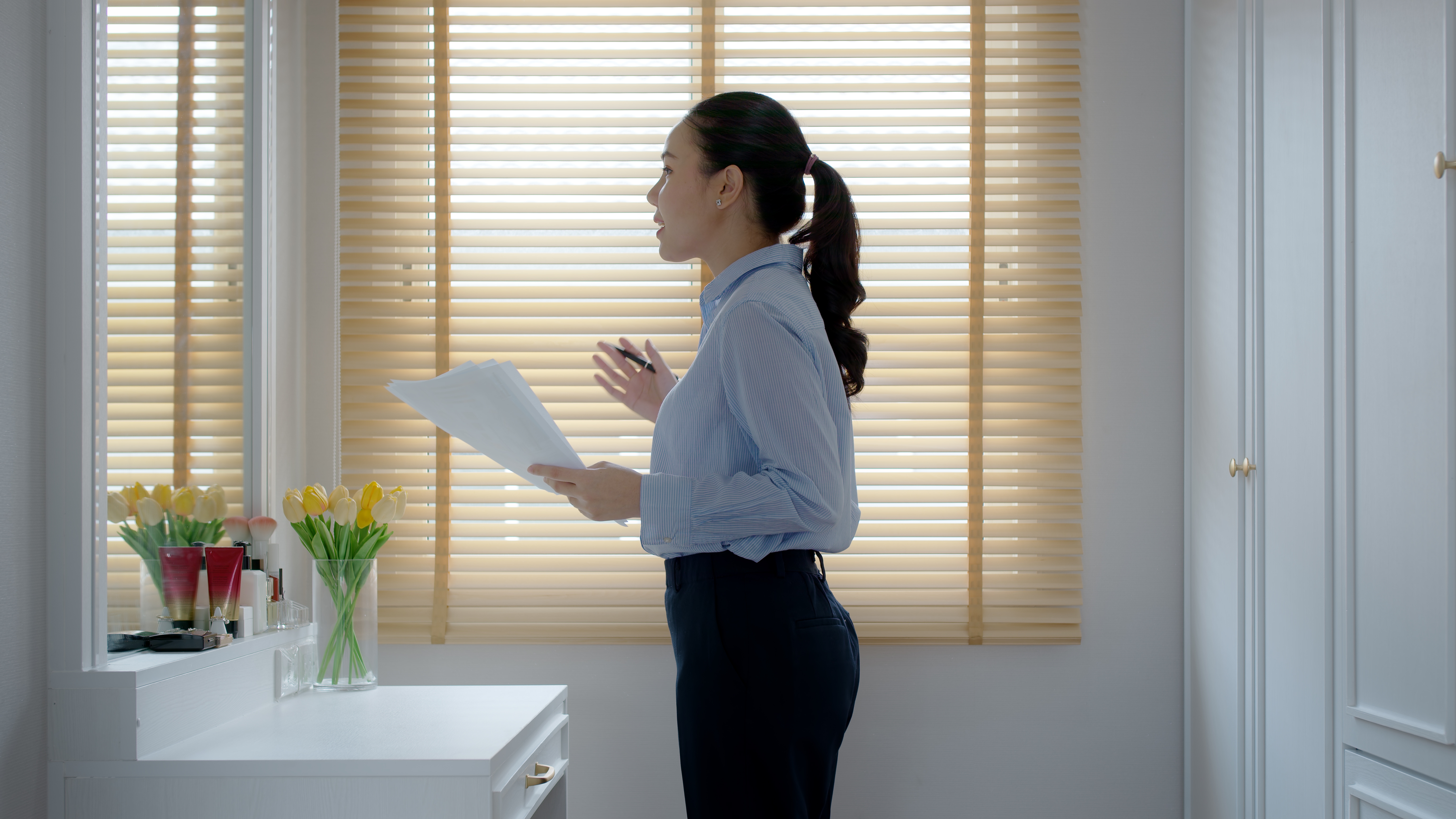 Young woman practicing speaking in front of a mirror