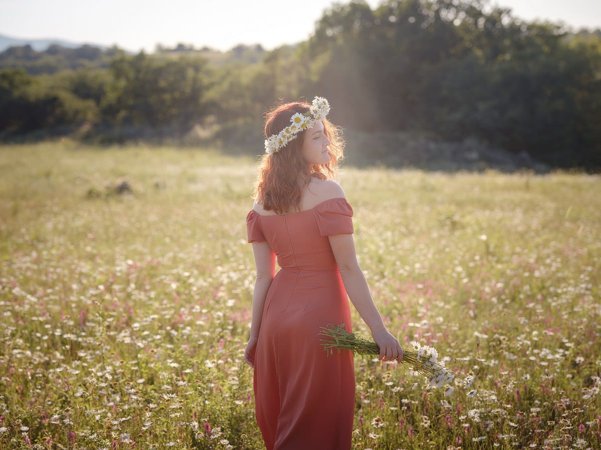 red-haired woman on a field on a summer evening
