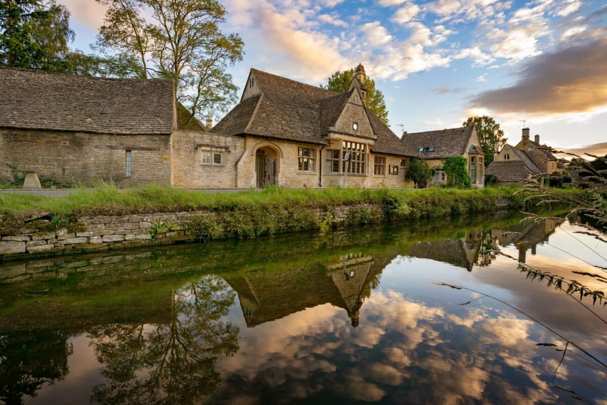 beautiful cottages and their reflection in the river at sunset 