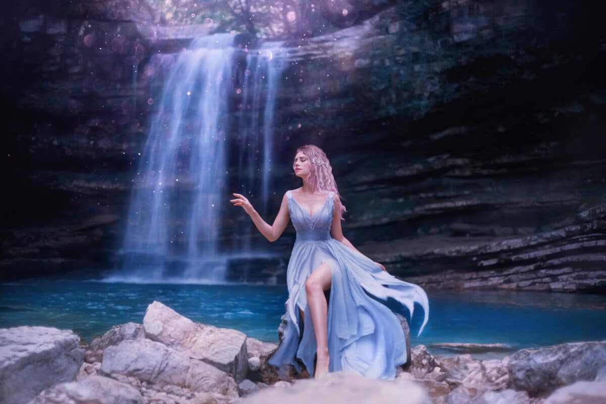 water fairy with a sad face standing on the rocks by the waterfall
