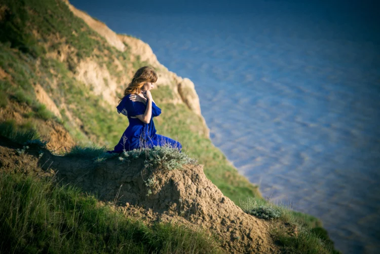 girl in a beautiful dress on a cliff above a precipice