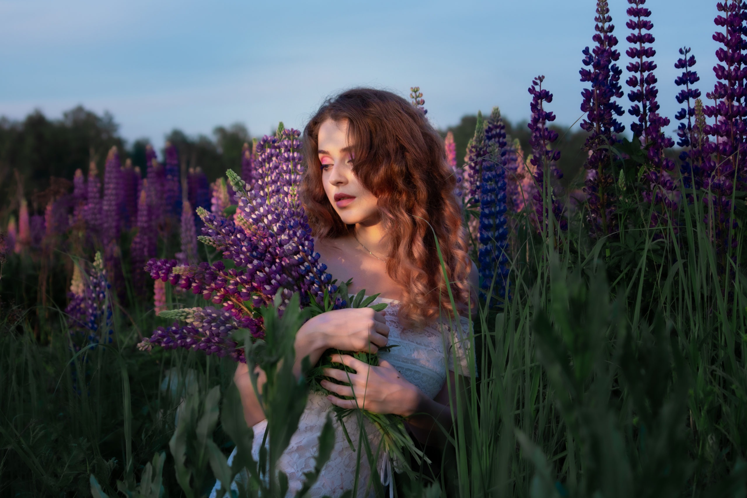 Beautiful, lovely girl among the purple flowers in the field.