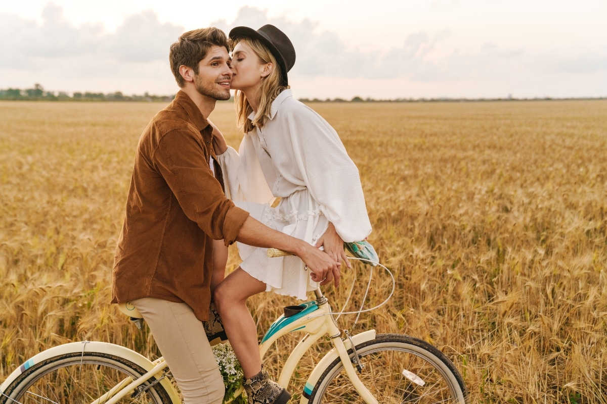 Image of young caucasian couple smiling and riding bicycle together