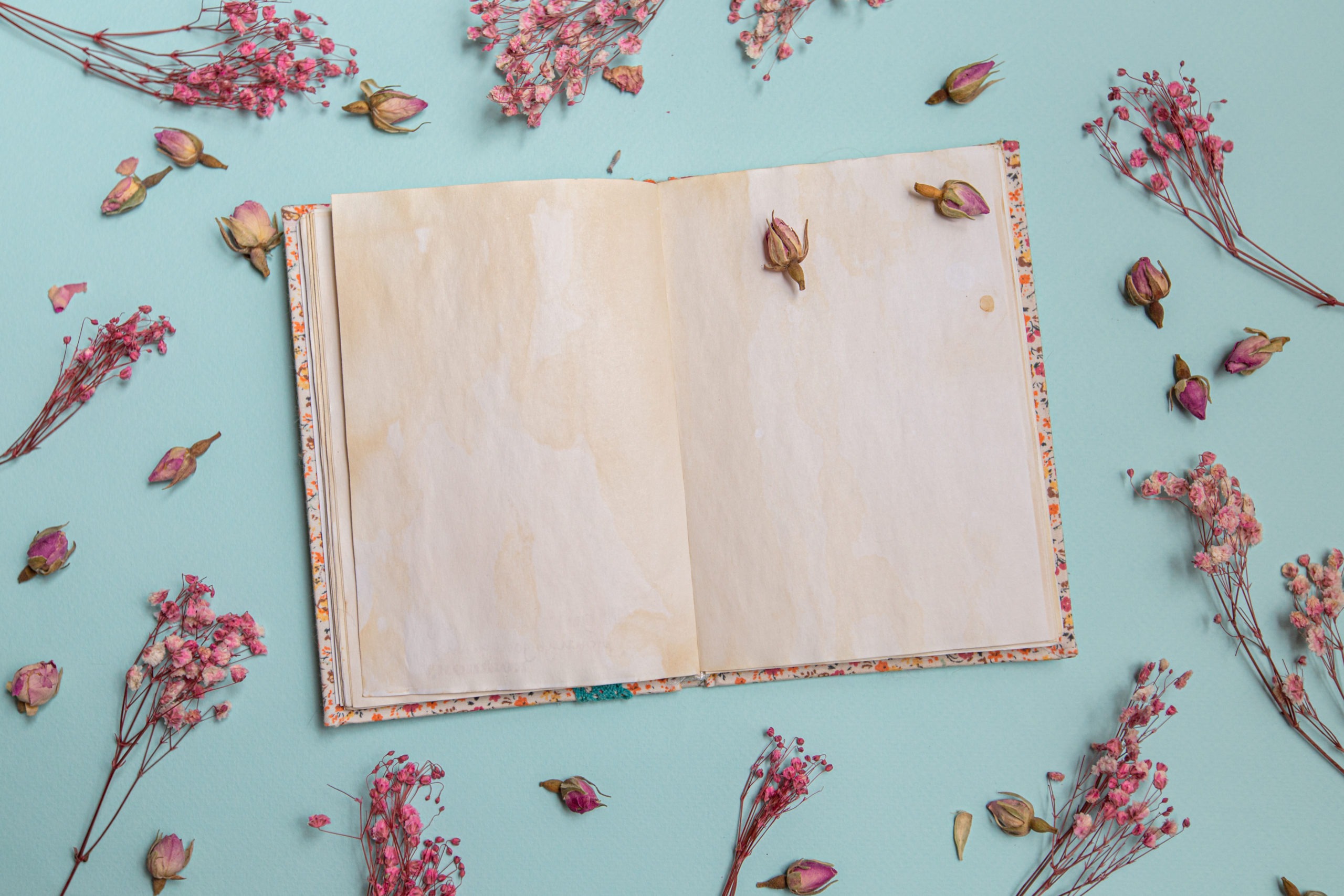 blank old notebook surrounded with tiny flowers