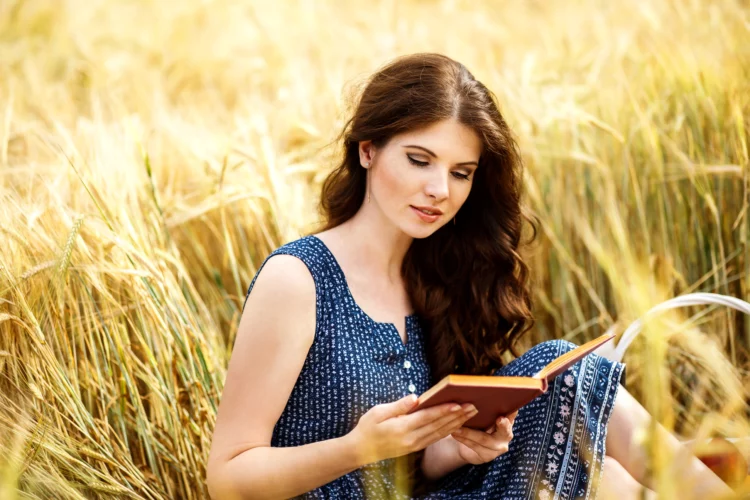 Woman reading in the middle of a field.