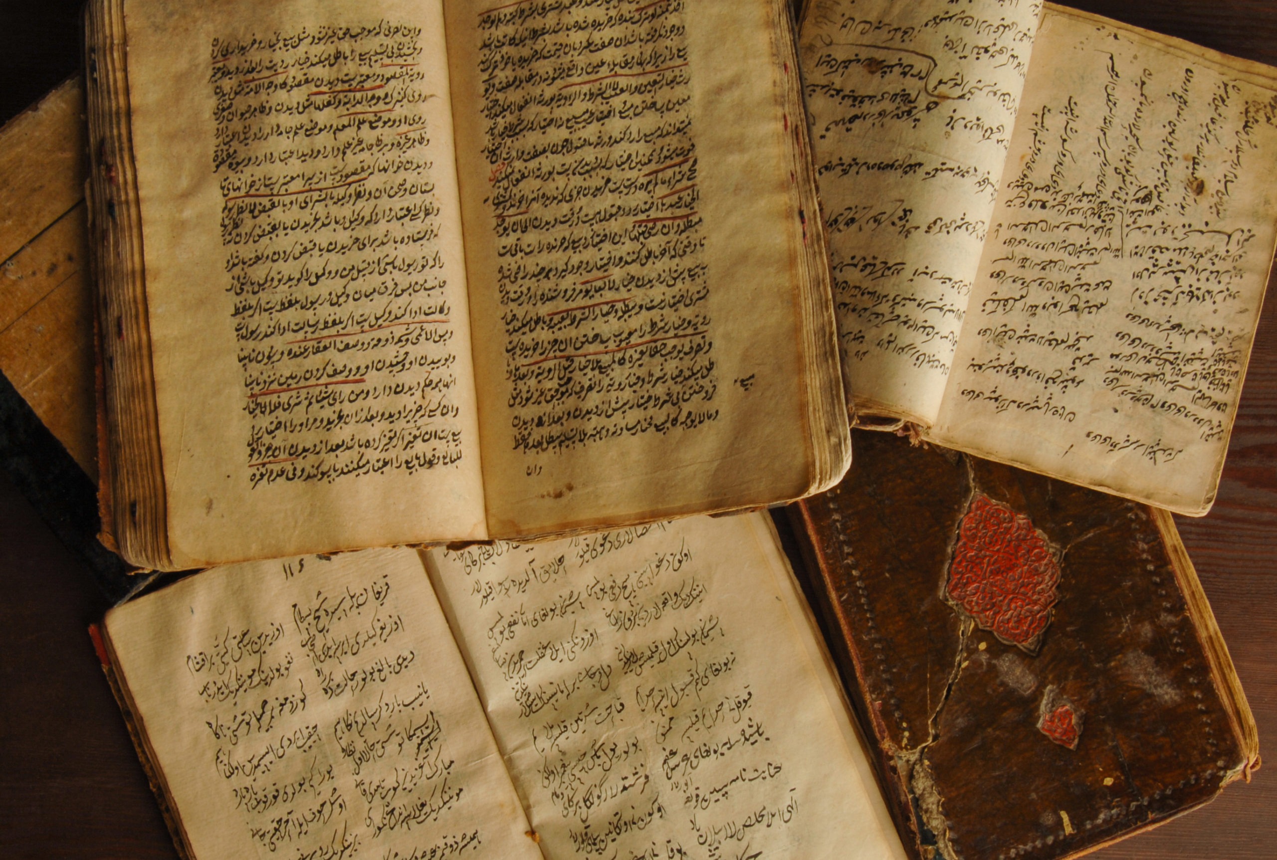 Ancient Arabic books opened on the table.