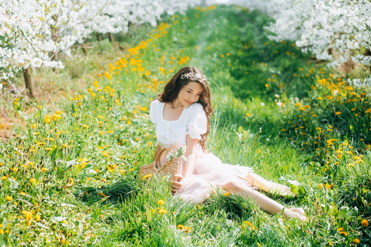Spring walk of a sweet girl in a vintage dress in a beautiful cherry orchard