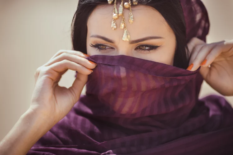 beautiful female in traditional ethnic costume and heavy gold jewelry and eye makeup