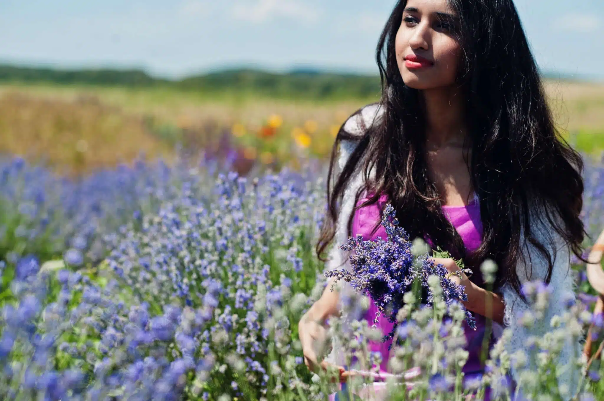 Beautiful indian girl in traditonal saree in a field of purple flowers