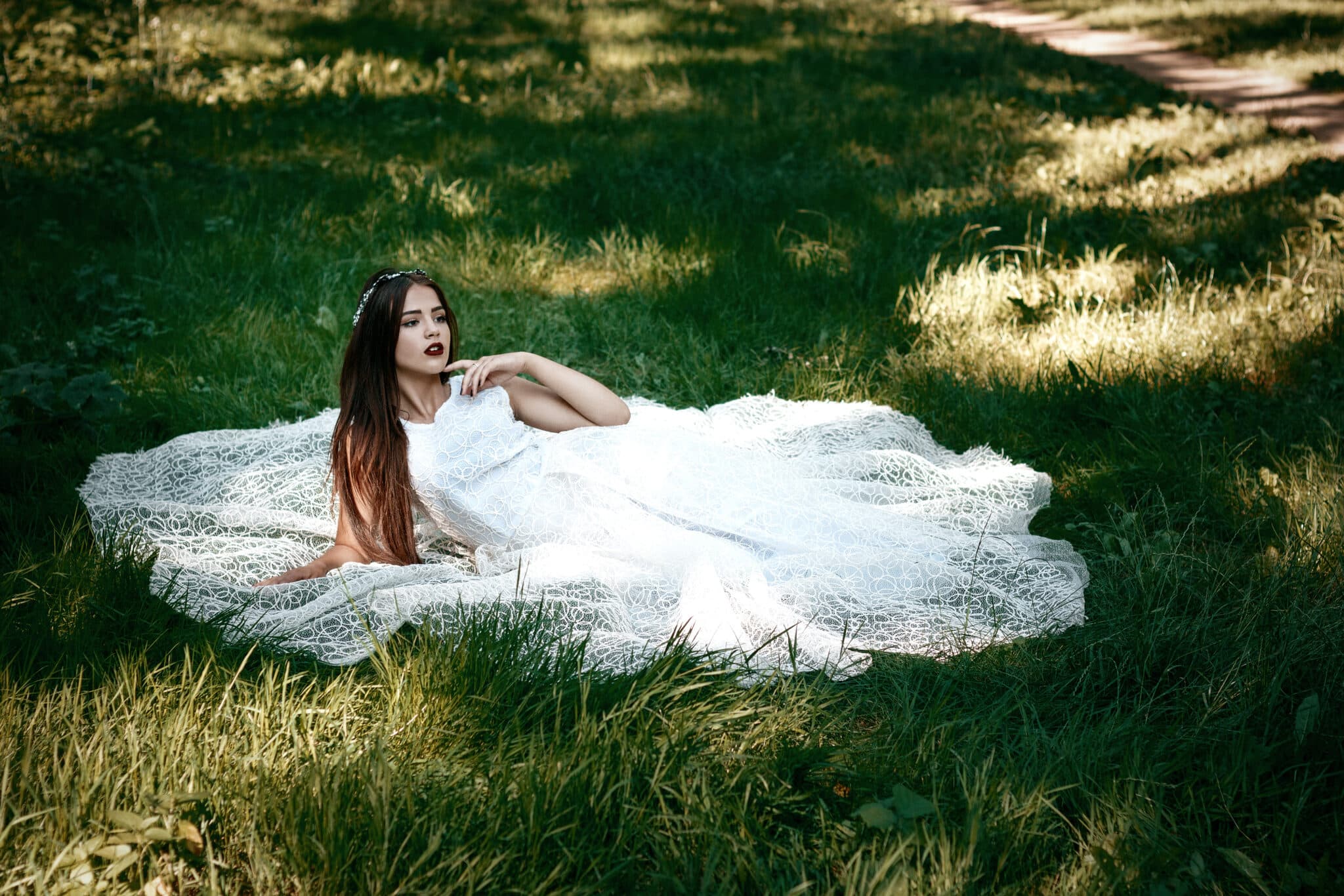 beautiful woman in a white dress sitting on the grass