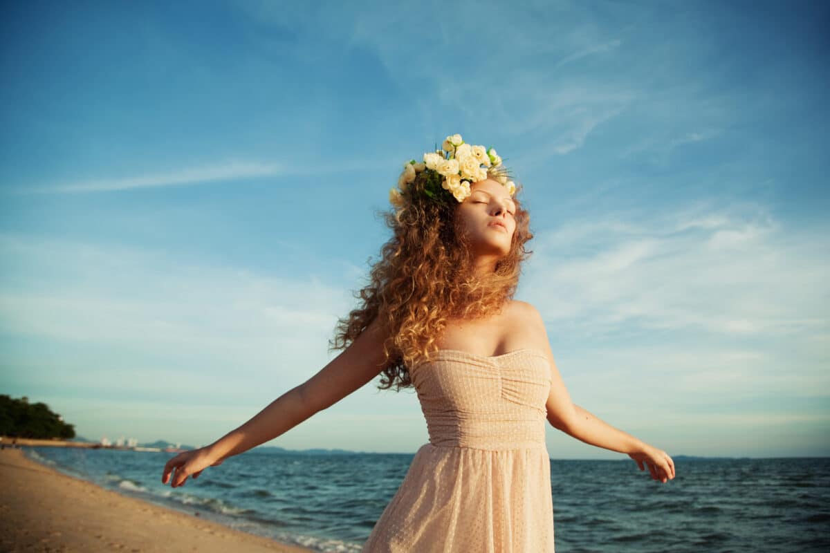 a lady in a flower crown relaxes on the beach